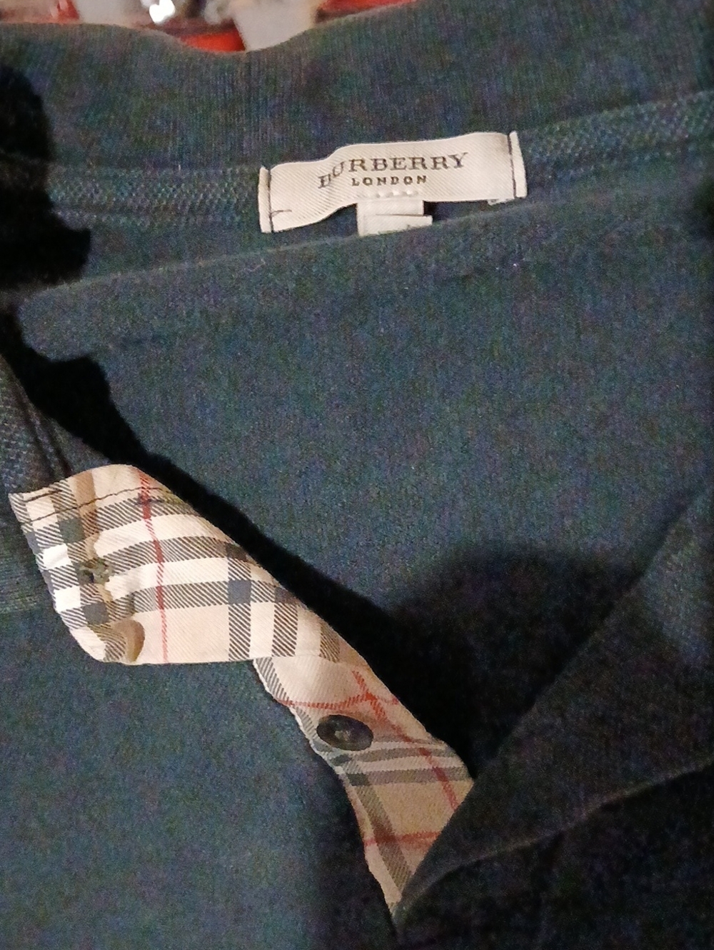 Burberry black polo with beige check placket.